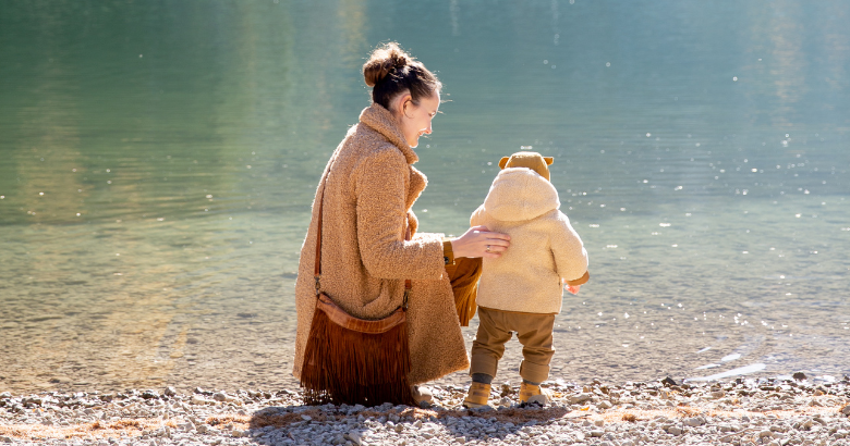 Mom and baby standing at the edge of a lake